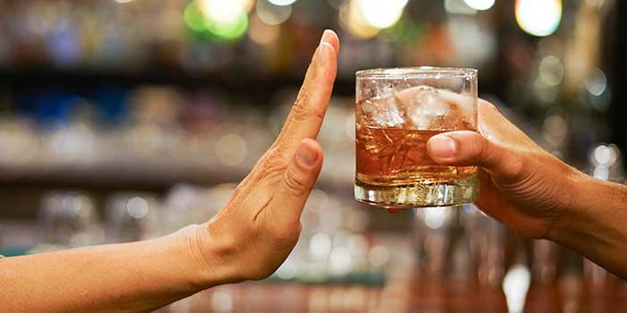 A person saying no to an alcoholic drink