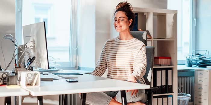 A woman meditating at a work desk