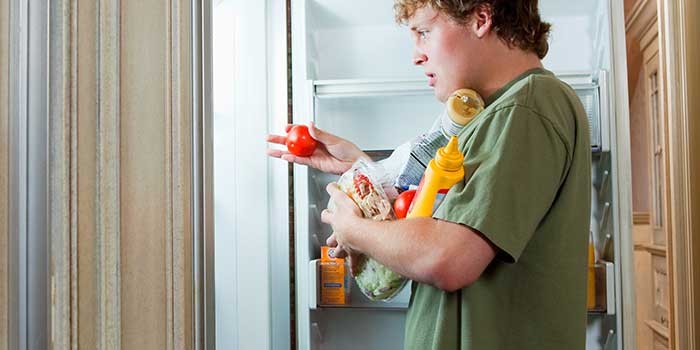 A young man raiding the fridge