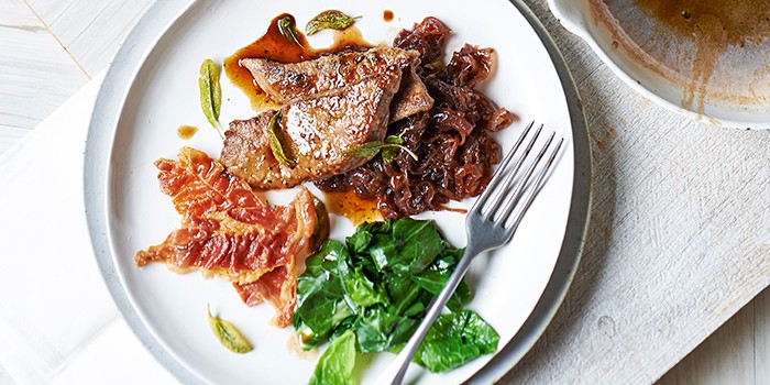 Calves’ liver with sticky onion relish & prosciutto on a white plate