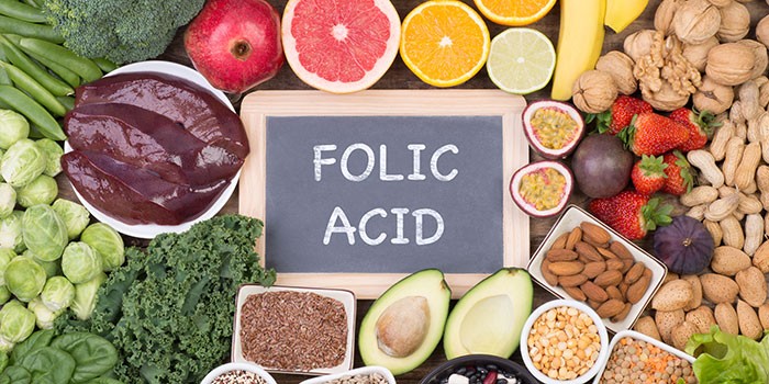 A sign reading 'folic acid' with foods surrounding it