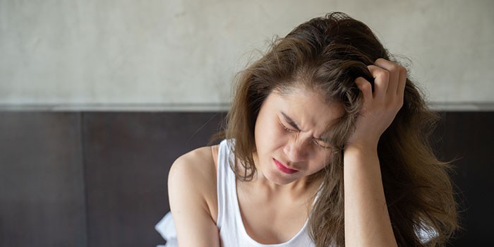 Woman looking grumpy with head in her hand