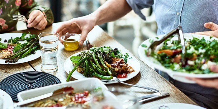 Man serving a healthy looking plate of delicious food at a dinner table