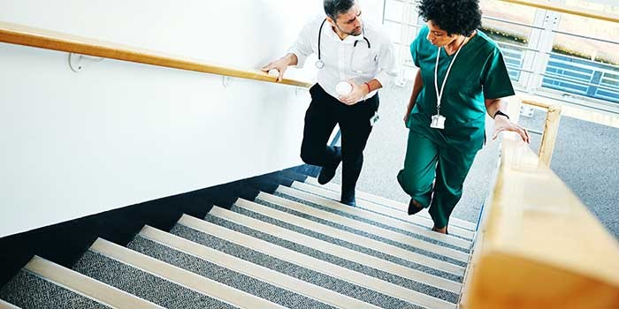 Two healthcare workers walking up stairs