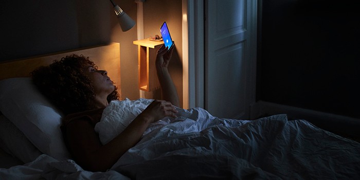 Woman using phone in bed