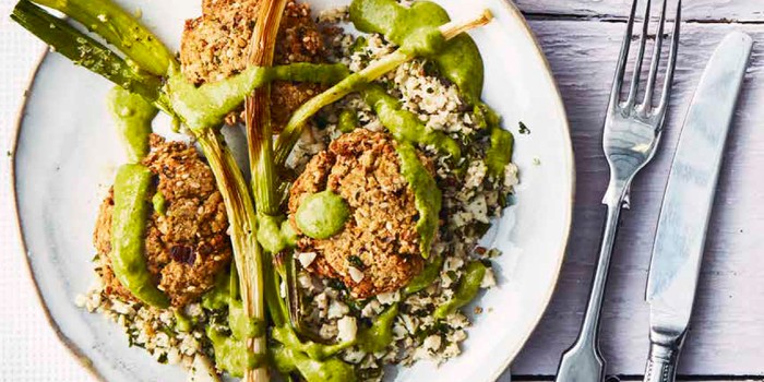 Baked falafel on a bed of cauliflower rice and topped with green tahini sauce
