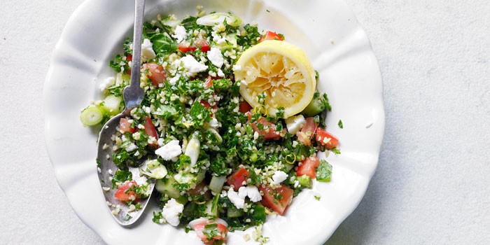 Kale salad with spoon on plate