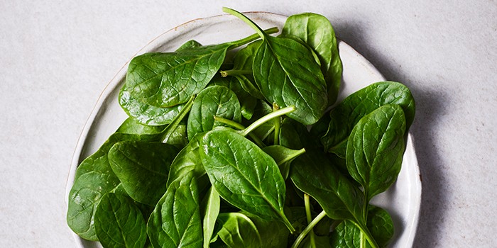 Close up of fresh spinach leaves in a white dish