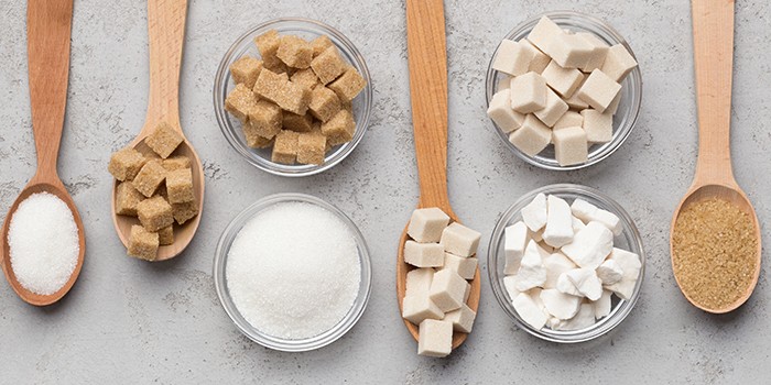 Bowls and spoons full of different types of sugar