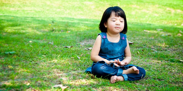 Toddler meditating outside