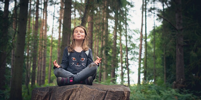 Girl meditating in woodland