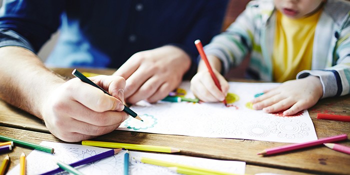 Boy and father colouring in