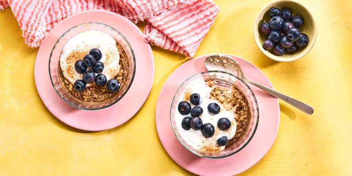 Two bowls of baked oats topped with yogurt and blueberries