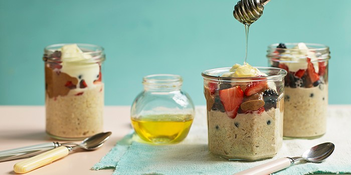 Overnight oats in a glass jar topped with fruit and honey
