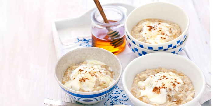 Three bowls of apple & linseed porridge, with a jar of honey