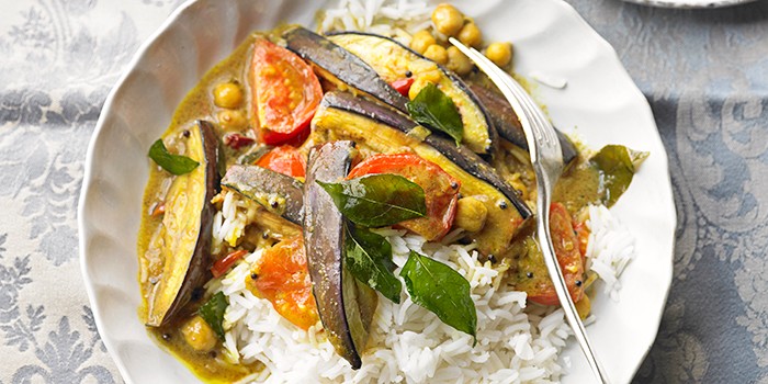 Aubergine and chickpea curry with white rice on a white place