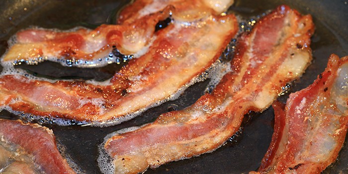 Sizzling bacon in a frying pan
