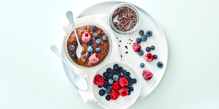 Chocolate and chia pudding with fruit in other bowls