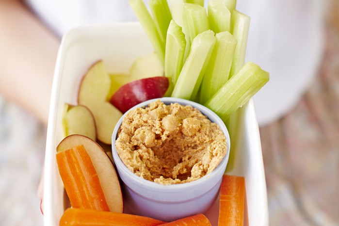 Ramekin of dip next to fingers of vegetables