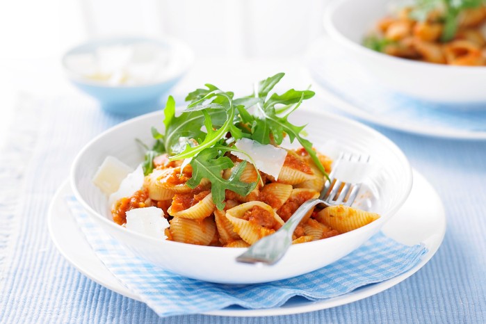 Bowl of pasta topped with rocket and parmesan shards