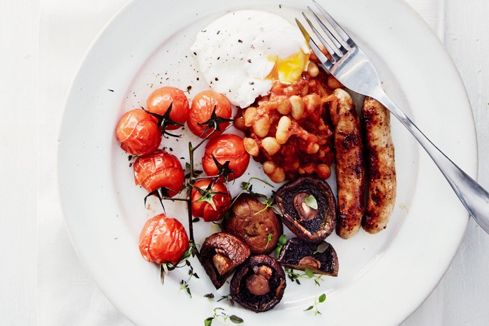 Plate with roasted cherry tomatoes, sausages, mushrooms, baked beans and fried egg on