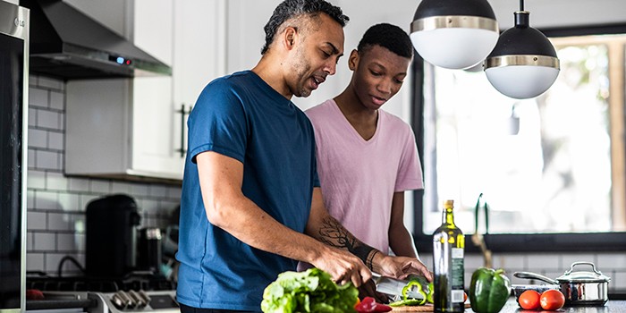 Father and son cooking together in kitchen