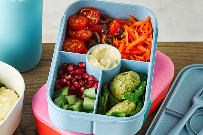 Lunchbox with falafel, cucumber, pomegranate seeds, tomatoes and carrot