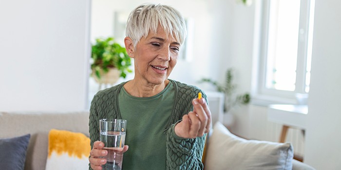 Woman taking vitamins with water