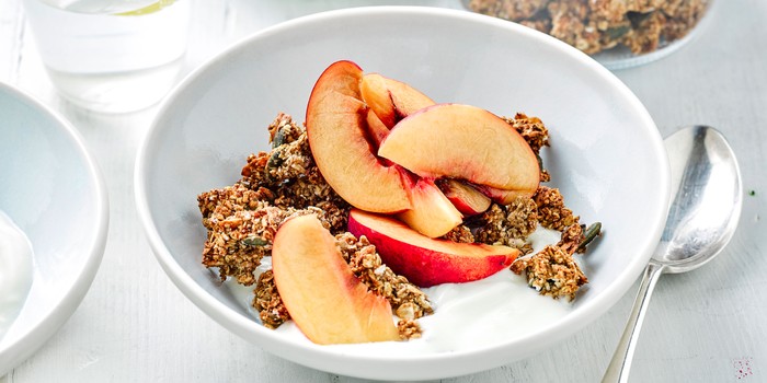 Bowl of oat clusters with peaches and yogurt
