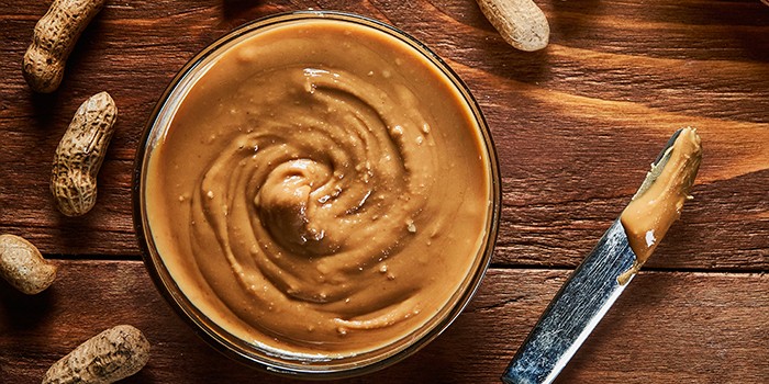 Peanut butter scattered on a slice of bread on rustic background