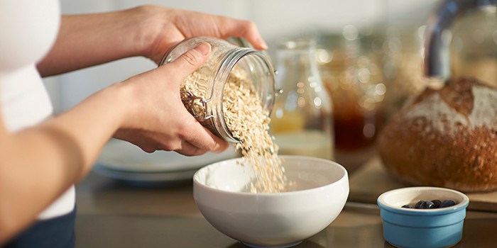 Woman pouring oats into bowl