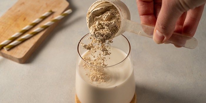 Pouring protein powder into a shake
