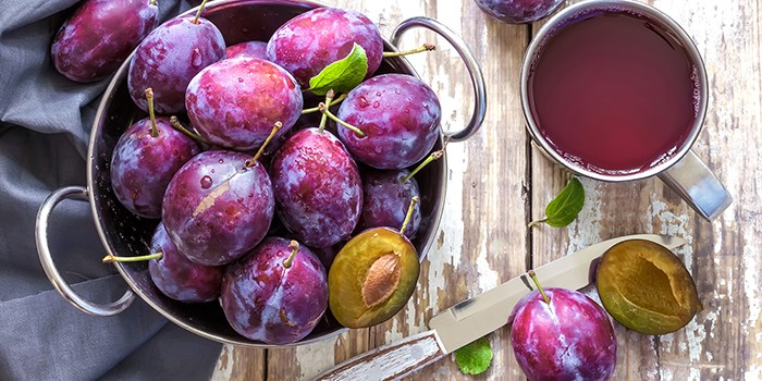 Prune juice and plums in a bowl