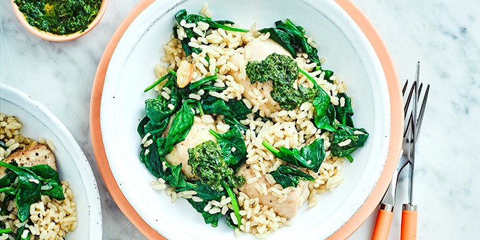 Roast chicken thighs with brown rice & salsa verde in a white dish