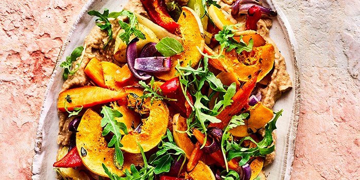 Roast squash & hummus winter salad on a stone background