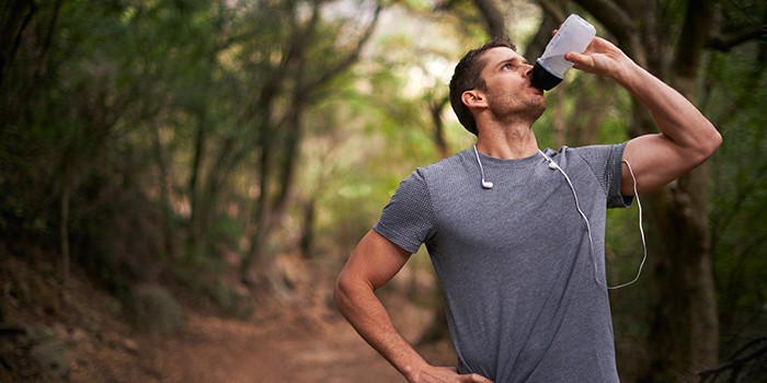 Male runner drinking water on a scenic run