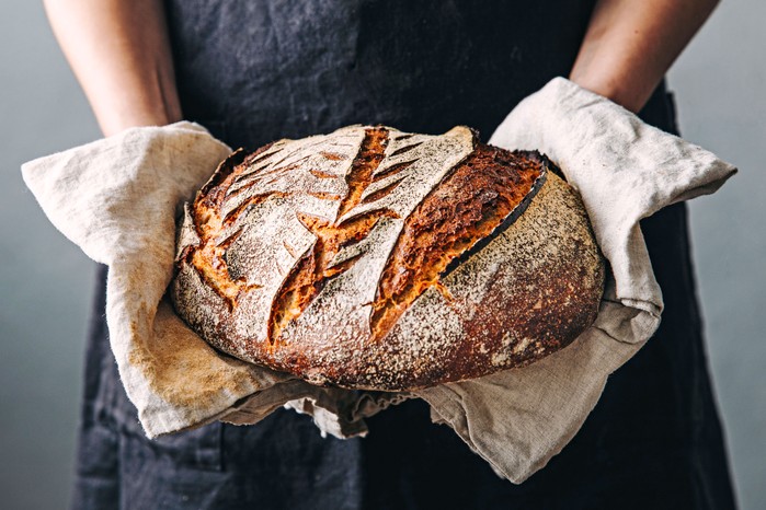 Hands holding sourdough loaf
