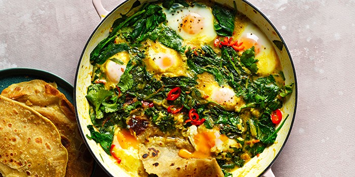 Spinach, coconut & turmeric baked eggs in a white casserole dish
