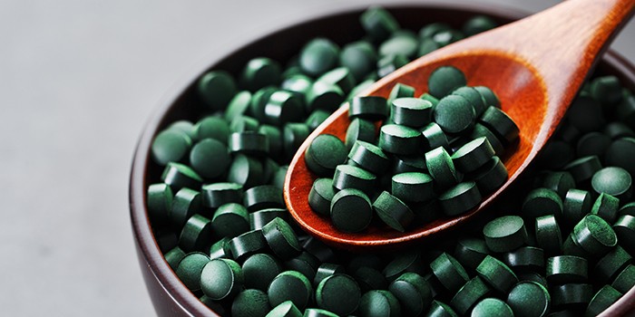 Spirulina tablets with a spoon