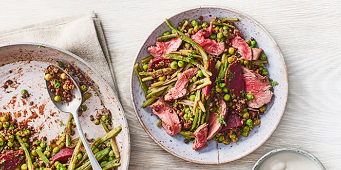 Steak, beetroot, horseradish & warm lentil salad on a blue plate