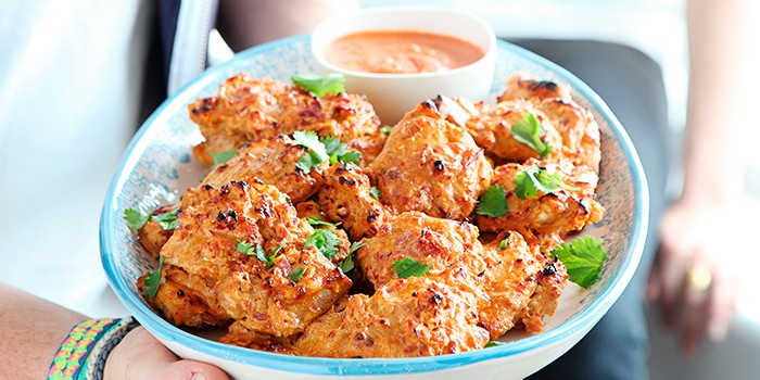Tandoori chicken on a plate with dipping sauce