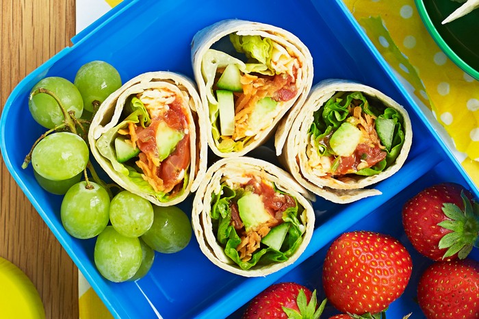 Veggie wraps and fruit in a lunchbox