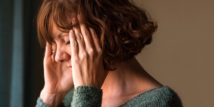 Close-up of woman with a headache and rubbing her temples