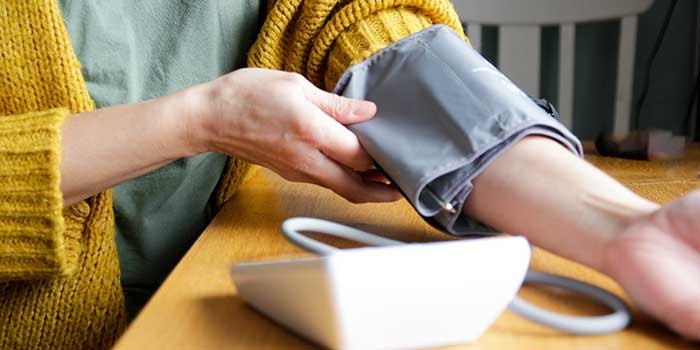 A person measuring their blood pressure at home