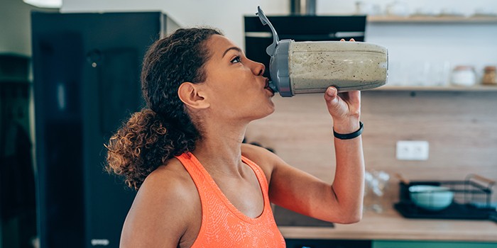 Young woman drinking protein shake after workout