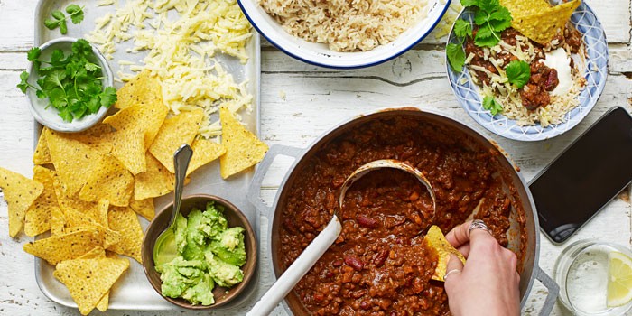 Burnt aubergine veggie chilli with nachos, rice, cheese and avocado
