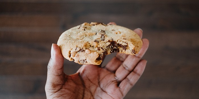 Hand holding large chocolate cookie