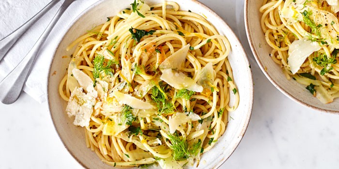 Fennel spaghetti in a bowl topped with parmesan