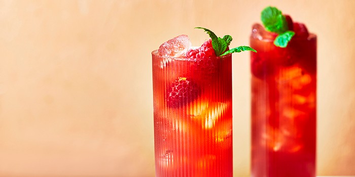 Two glasses of brightly coloured goji berry and raspberry cooler