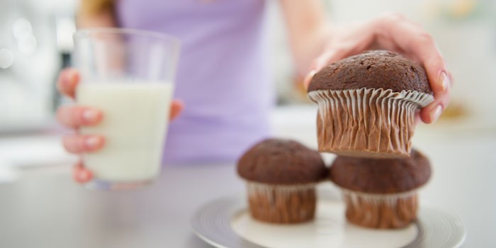 how-much-sugar-should-i-eat-woman-reaching-for-muffin-ebc49e4